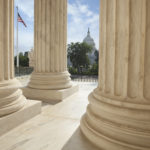Supreme Court columns with American flag and US Capitol