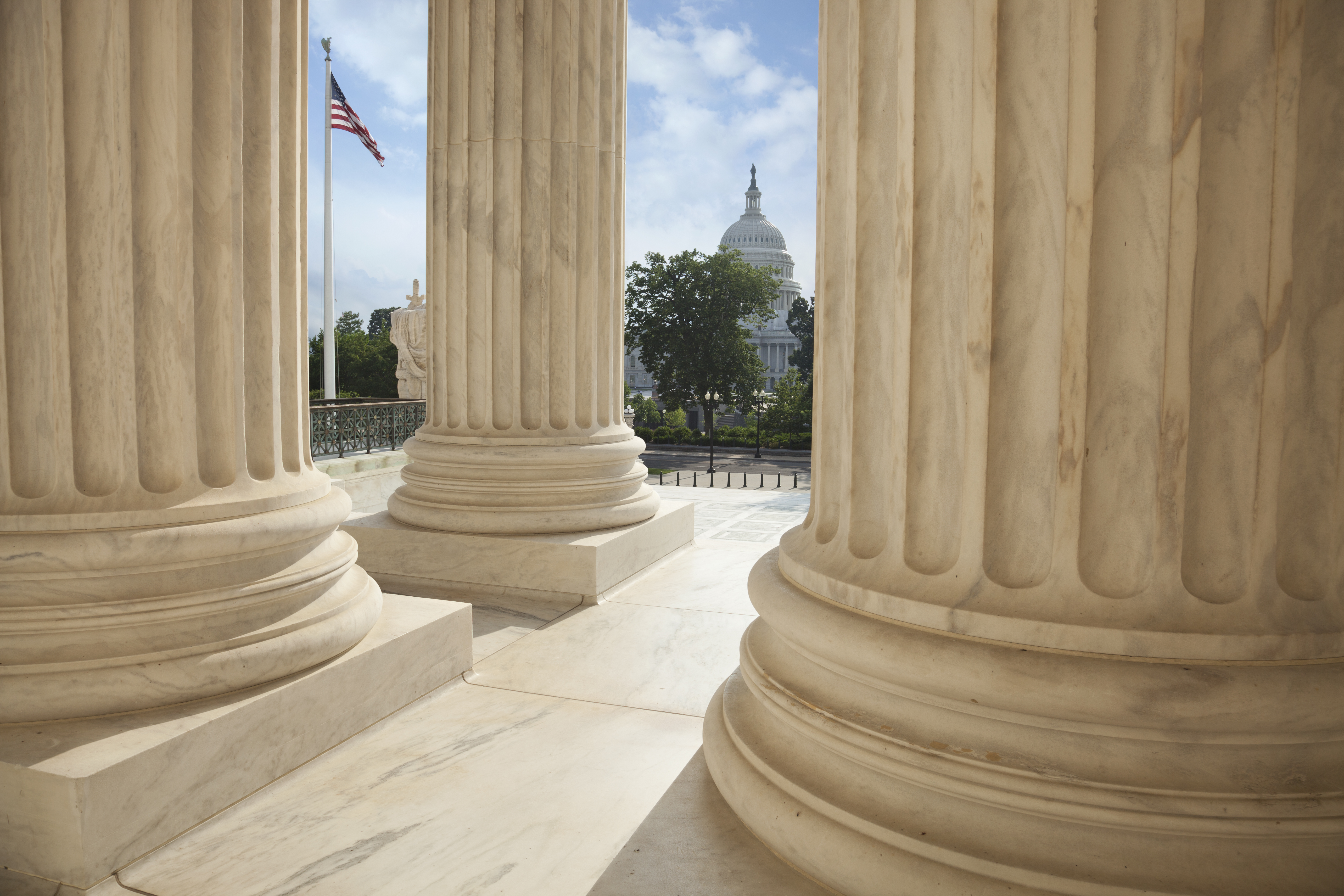 Supreme Court columns with American flag and US Capitol